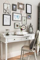 Classic desk and chair and display of framed pictures 
