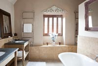 Modern bathroom with bare plaster feature wall 