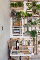Display of houseplants on pallet covered wall 