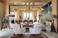 Living room with plentiful seating, modern art and exposed ceiling beams