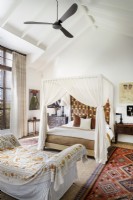 Four-poster bed and daybed in bedroom with pitched ceiling