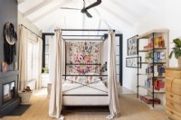 bedroom with four-poster bed and embroidered wall hanging