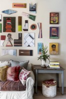Collection of artworks above sofa with cushions