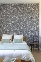 Patterned wallpapered feature wall in vintage style bedroom