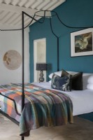 Bedroom with four-poster bed and teal feature wall