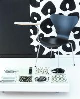 A black and white interior a black chair with small side table