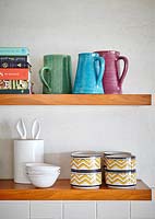 Colourful crockery on kitchen shelves