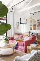 Pink sofa and exposed wooden trusses in living room